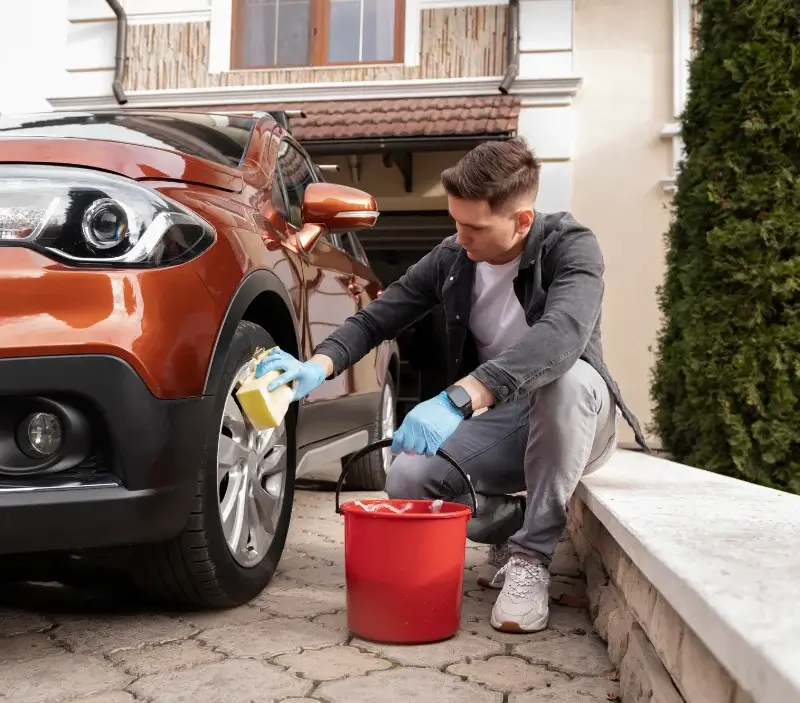Lavage auto à domicile Limbrassac : professionnel intervenant sur un véhicule